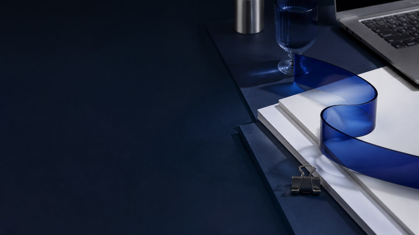 Art-directed financial workspace with ordered documents and a sculptural blue line